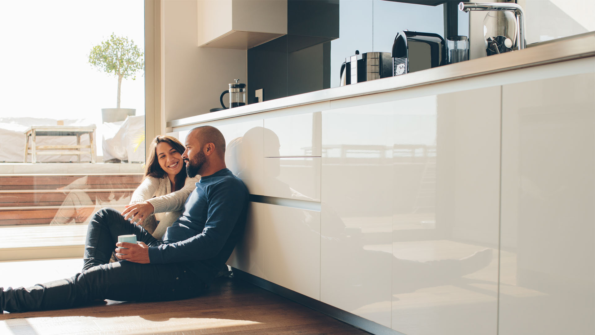 Image showing a smiling couple sitting on their kitchen floor together