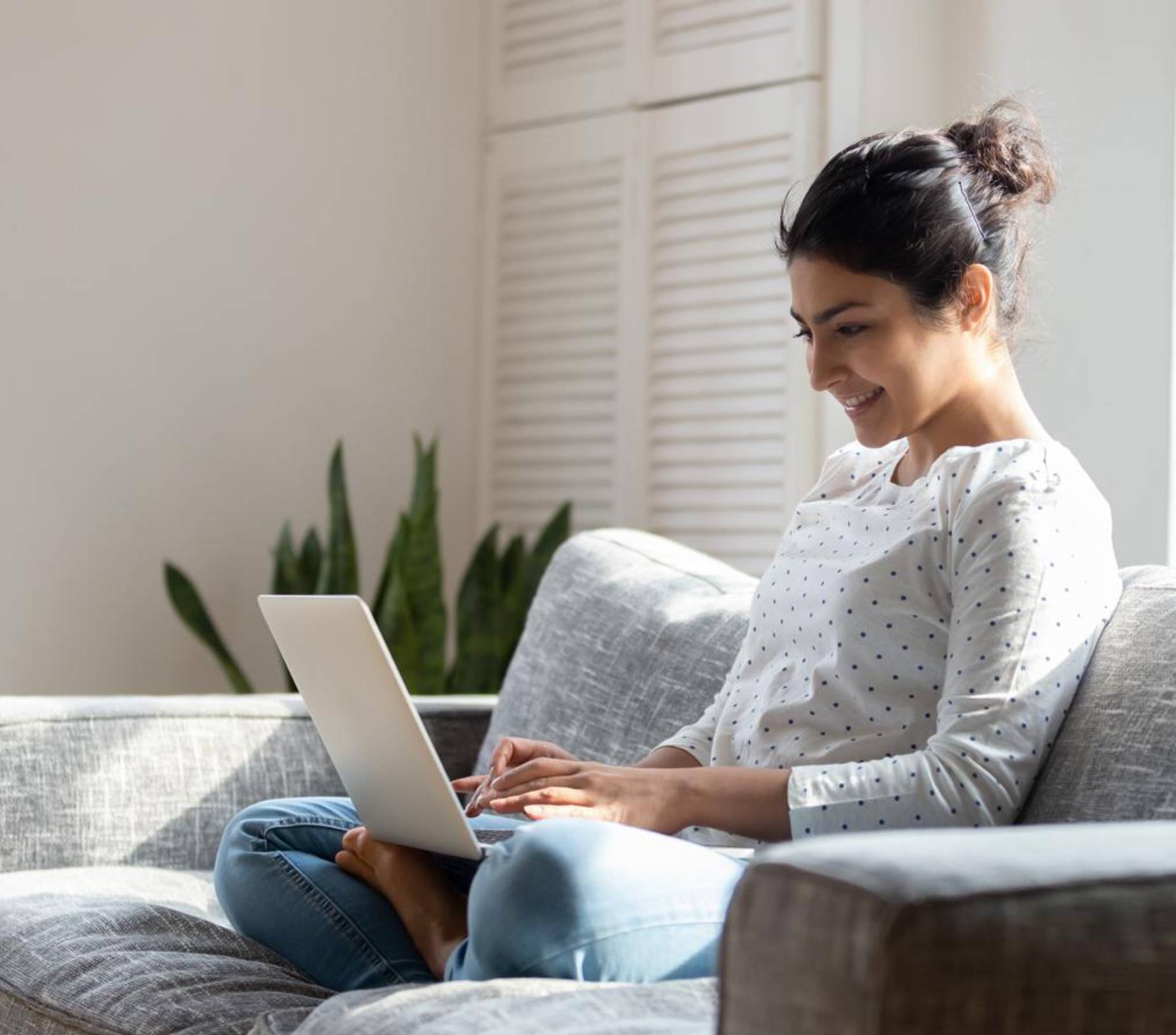 Image showing a woman sitting on her couch using her laptop