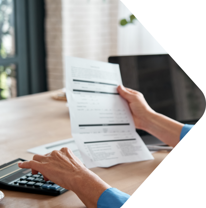 Image showing a person using a calculator and holding a piece of paper