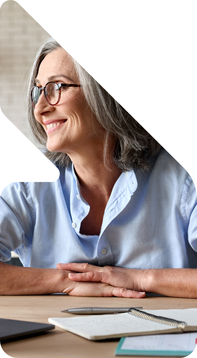 Image showing an old lady smiling with papers in front of her on the desk