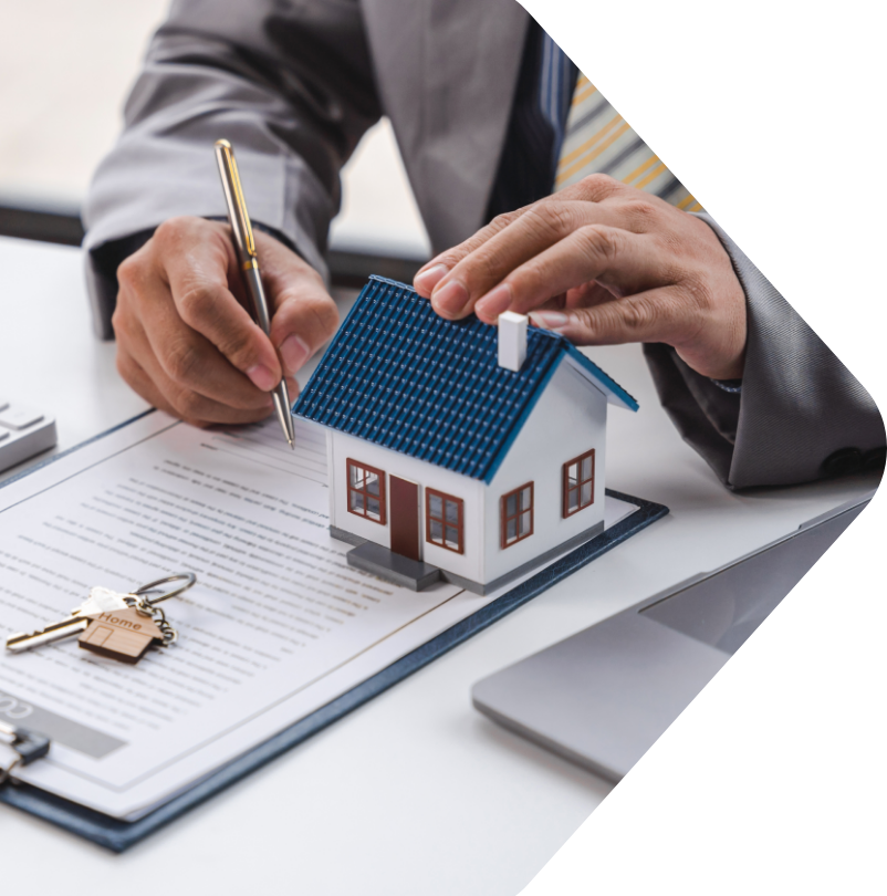 Image showing a close up of a man working on a contract while holding a model house